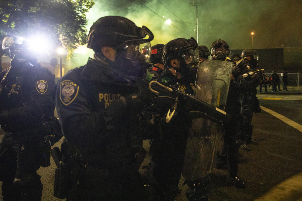 FILE - In this Sept. 18, 2020, file photo, tear gas fills the air as police take control of the streets during protests in Portland, Ore. An Oregon lawmaker is seeking to ban the use of tear gas and other agents against crowds of people in one of the most sweeping police measures in the country regarding crowd control devices. (AP Photo/Paula Bronstein, File)