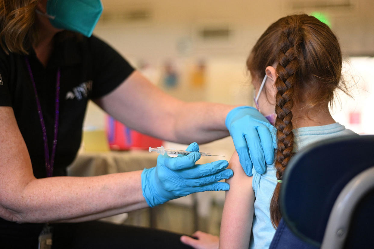 A nurse administers a pediatric dose of the Covid-19 vaccine to a girl ROBYN BECK/AFP via Getty Images