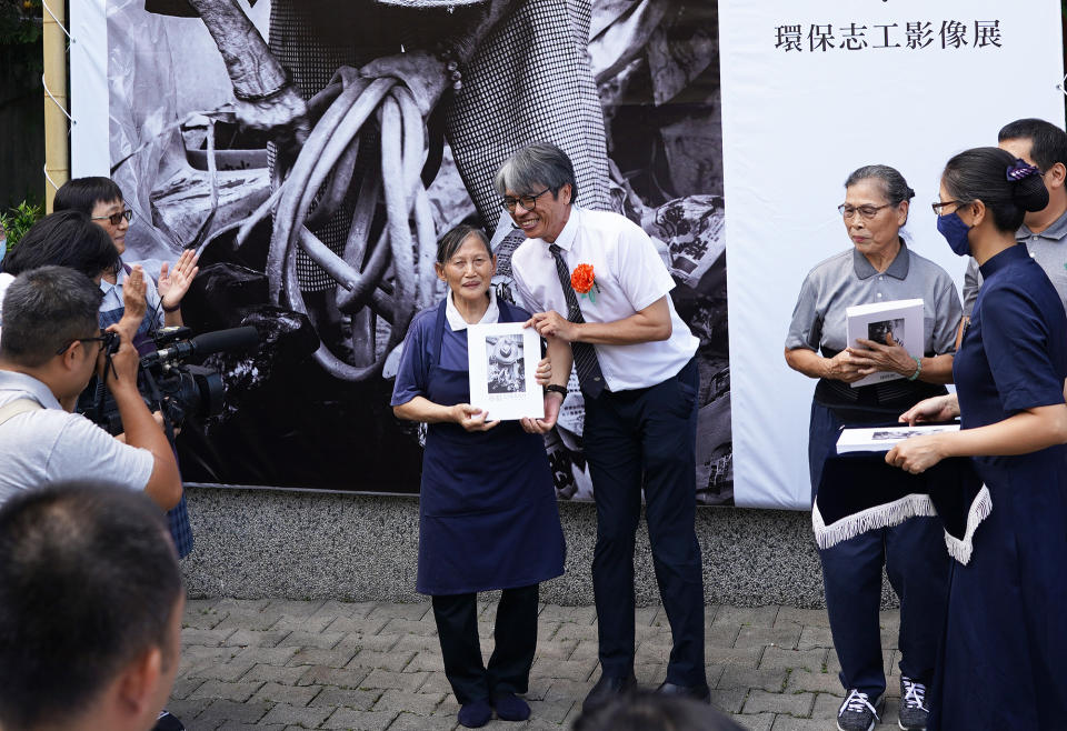 慈濟人文志業中心平面媒體總監王志宏代表贈書給環保志工林阿屘