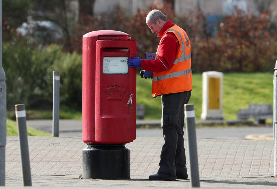 A Royal Mail postman empties a postbox near the SEC Centre in Glasgow which is being turned into a temporary NHS hospital to help tackle the coronavirus outbreak.