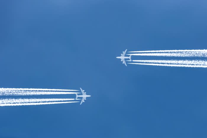 Two planes flying against a blue background.