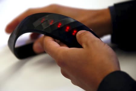 Industrial designer Braden Wilson holds a protype of a device called a "Brainband" during a demonstration of the thick black headband in Sydney, Australia, March 22, 2016. REUTERS/David Gray