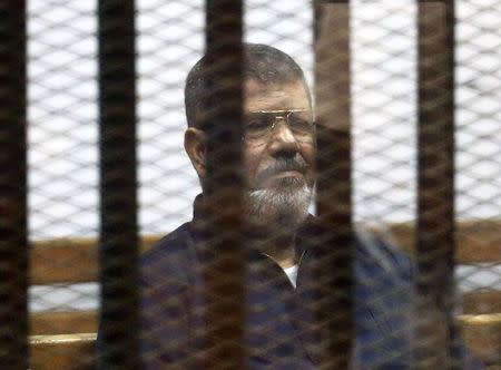 FILE PHOTO - Deposed Egyptian President Mohamed Mursi listens to his verdict behind bars at a court on the outskirts of Cairo, Egypt June 16, 2015. REUTERS/Asmaa Waguih/File Photo