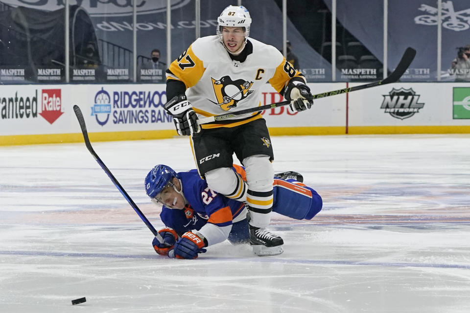 New York Islanders center Anders Lee (27) falls to the ice after colliding with Pittsburgh Penguins center Sidney Crosby (87) during the second period of an NHL hockey game, Sunday, Feb. 28, 2021, in Uniondale, N.Y. (AP Photo/Kathy Willens)