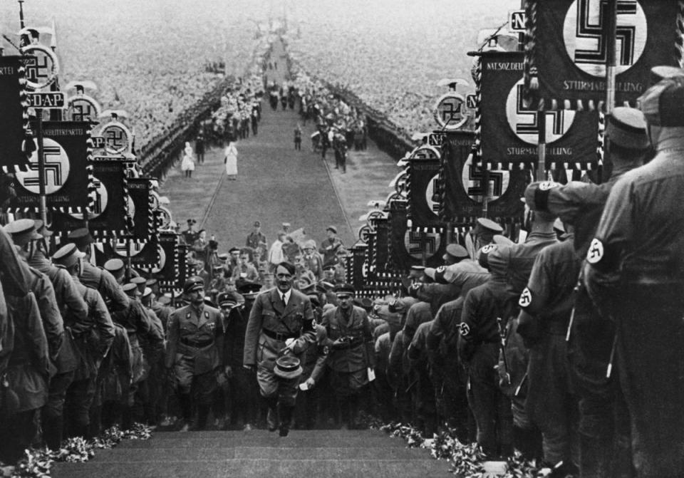 Adolf Hitler ascending the steps at Buckeberg in 1934, flanked by banner-carrying stormtroopers (Getty)