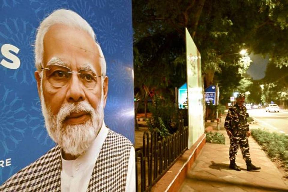 Indian security personnel stands guard next to G20 communication billboard with a portrait of India' prime minister Narendra Modi (AFP via Getty Images)