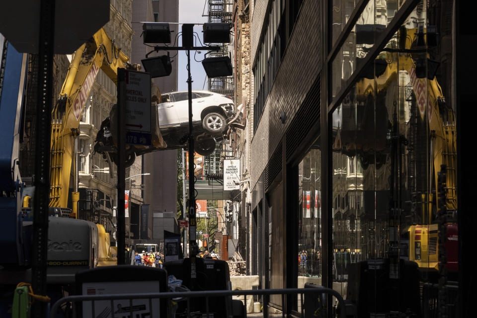 A car is removed from a partially collapsed parking garage in the Financial District of New York, Wednesday, April 19, 2023. (AP Photo/Yuki Iwamura)