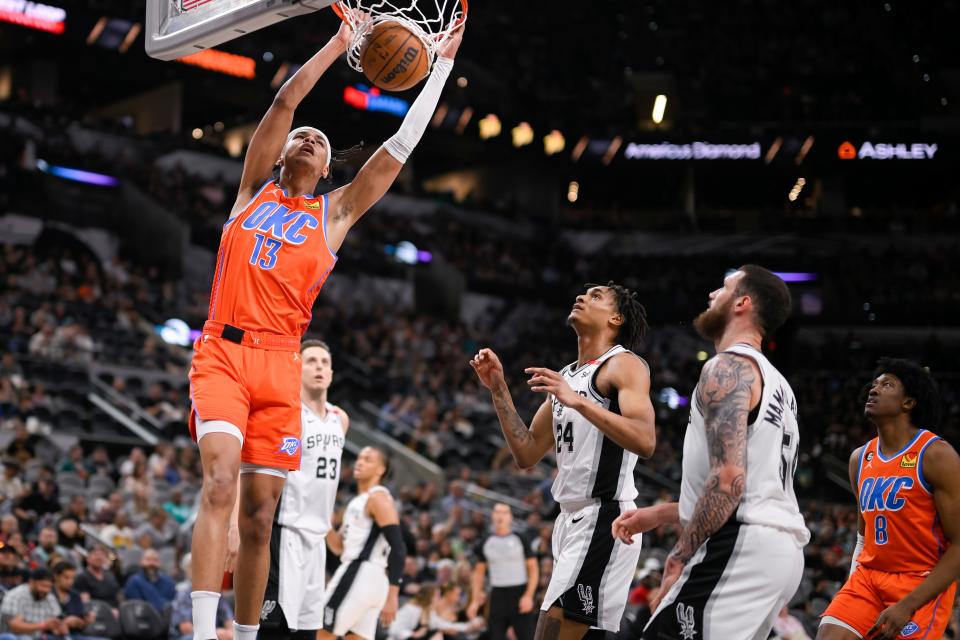 Oklahoma City Thunder's Ousmane Dieng (13) dunks during the first half of an NBA basketball game against the San Antonio Spurs, Sunday, March 12, 2023, in San Antonio. (AP Photo/Darren Abate)