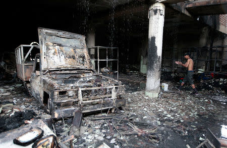 A man stands inside a burned house where, according to local media, six people died, during a protest against Nicaragua's President Daniel Ortega's in Managua, Nicaragua June 16, 2018. REUTERS/Oswaldo Rivas