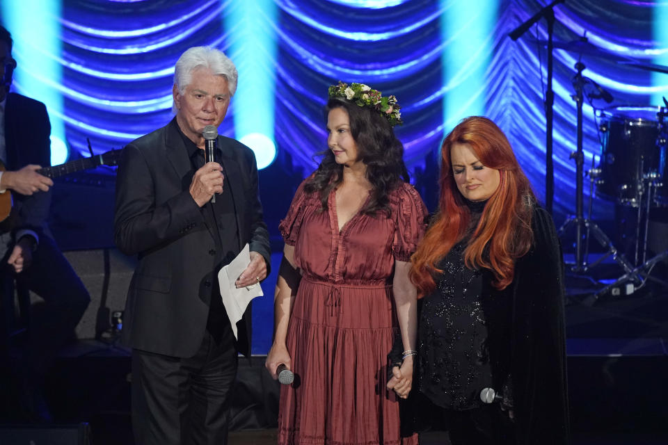 Larry Strickland, left, husband of Naomi Judd; Ashley Judd, center; and Wynonna Judd speak during a tribute to country music star Naomi Judd Sunday, May 15, 2022, in Nashville, Tenn. Naomi Judd died April 30. She was 76. (AP Photo/Mark Humphrey)