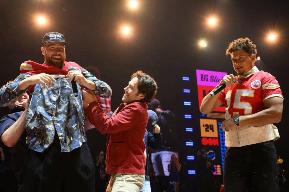 Travis Kelce had to be helped into a No. 87 jersey by Eric Stonestreet, left, and Paul Rudd as Patrick Mahomes squeezed into his at the Big Slick Party & Show on Saturday. The jerseys were part of an NFL package that sold for $250,000.