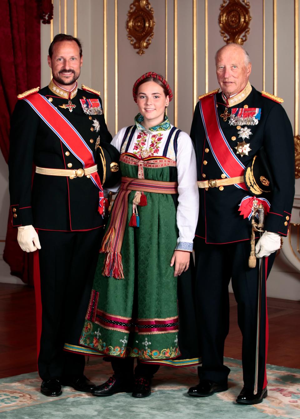 Dressed in a national costume, Ingrid Alexandra posed for a photo with grandfather King Harald and father Crown Prince Haakon.