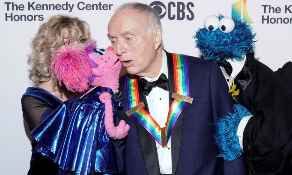 Sesame Street co-creator Lloyd Morrisett receives a kiss from Abby Cadabby as the Cookie Monster watches.