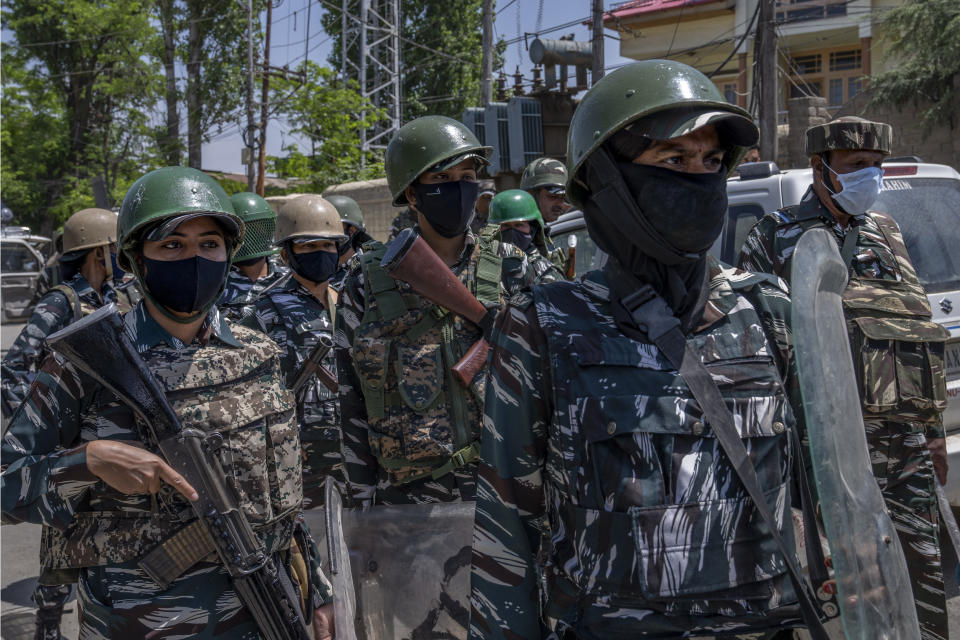 Paramilitary soldiers stand guard during a protest by Kashmiri Hindus, locally known as Pandits, against the killing of Rahul Bhat, also a Pandit, on the outskirts of Srinagar, Indian controlled Kashmir, Friday, May 13, 2022. Hindus in Indian-controlled Kashmir staged protests on Friday a day after assailants shot and killed the government employee from the minority community. It was the first time that Pandits, an estimated 200,000 of whom fled Kashmir after an anti-India rebellion erupted in 1989, simultaneously organized street protests at several places in the Muslim-majority region. (AP Photo/Dar Yasin)