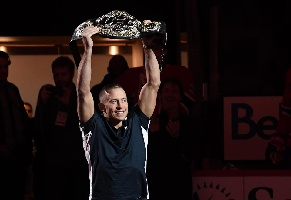 George St-Pierre holds up his middleweight title belt prior to an NHL game at the Bell Centre on Nov. 14, 2017 in Montreal. (Getty Images)