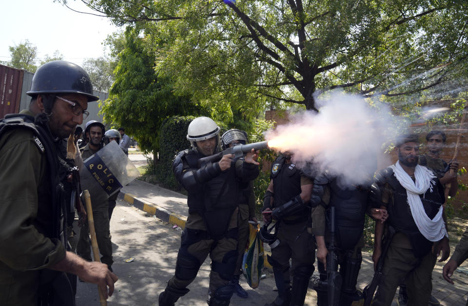 Police fire tear gas to disperse supporters of Pakistan's former Prime Minister Imran Khan protesting against the arrest of their leader, in Lahore, Pakistan, Wednesday, May 10, 2023. Khan can be held for eight days, a court ruled Wednesday, a day after the popular opposition leader was dragged from a courtroom and arrested on corruption charges, deepening the country's political turmoil. (AP Photo/K.M. Chaudary)