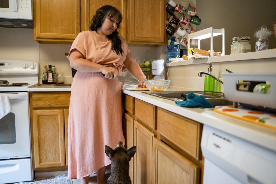Richelle Dietz prepares a snack for her daughter at her home on Monday, April 22, 2024, in Honolulu, Hawaii. Dietz stopped using the tap water to wash their produce after finding sheens last October. (AP Photo/Mengshin Lin)