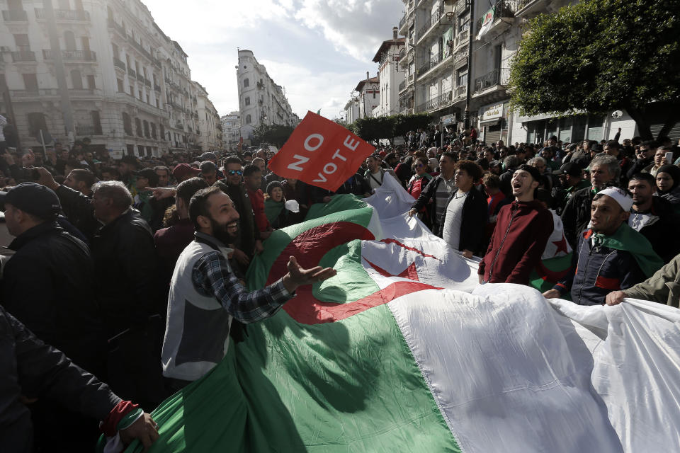 Algerian demonstrators take to the streets in the capital Algiers to reject the presidential elections, in Algeria, Thursday, Dec. 12, 2019. Five candidates have their eyes on becoming the next president of Algeria _ without a leader since April _ in Thursday's contentious election boycotted by a massive pro-democracy movement. (AP Photo/Toufik Doudou)