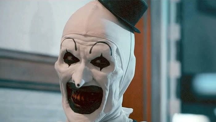 a clown with a scary mouth gives a haunting smile in a scene from terrifier, a good housekeeping pick for best halloween movies