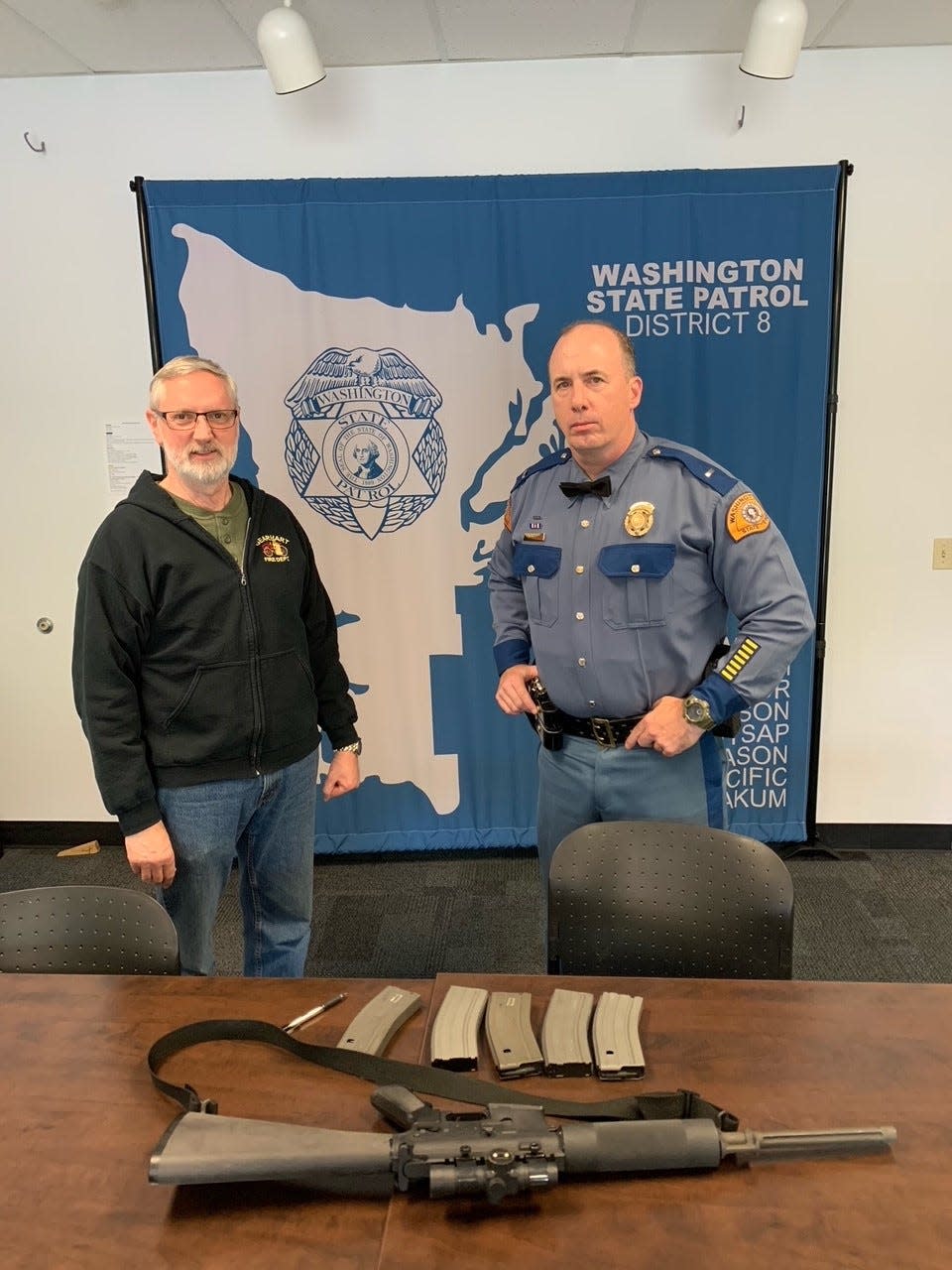 Jeff Gearhart of Port Orchard and WSP Lt. Bill Steen are shown Thursday at the State Patrol's district headquarters in Bremerton with Gearhart's AR-15-type rifle. After reflecting on recent massacres using a similar firearm, Gearhart surrendered his rifle for destruction.