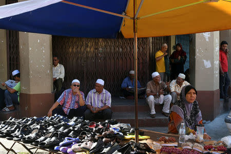 People sit next to a shoe stall as they attend a 'ceramah' or religous lecture in Kota Bharu, Kelantan, Malaysia April 13, 2018. REUTERS/Stringer