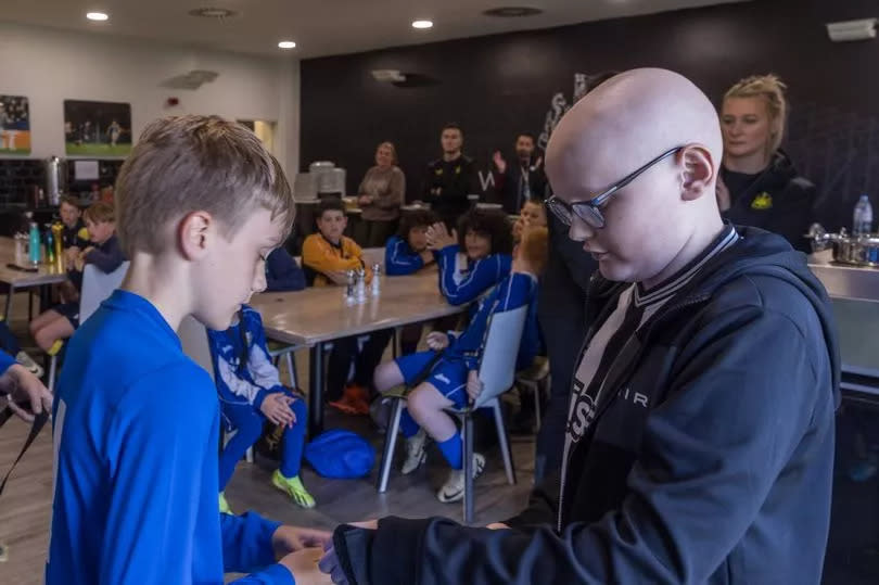 Ethan O'Neill who has Hodgkin's lymphoma presenting medals after a charity football tournament for youngsters affected by cancer