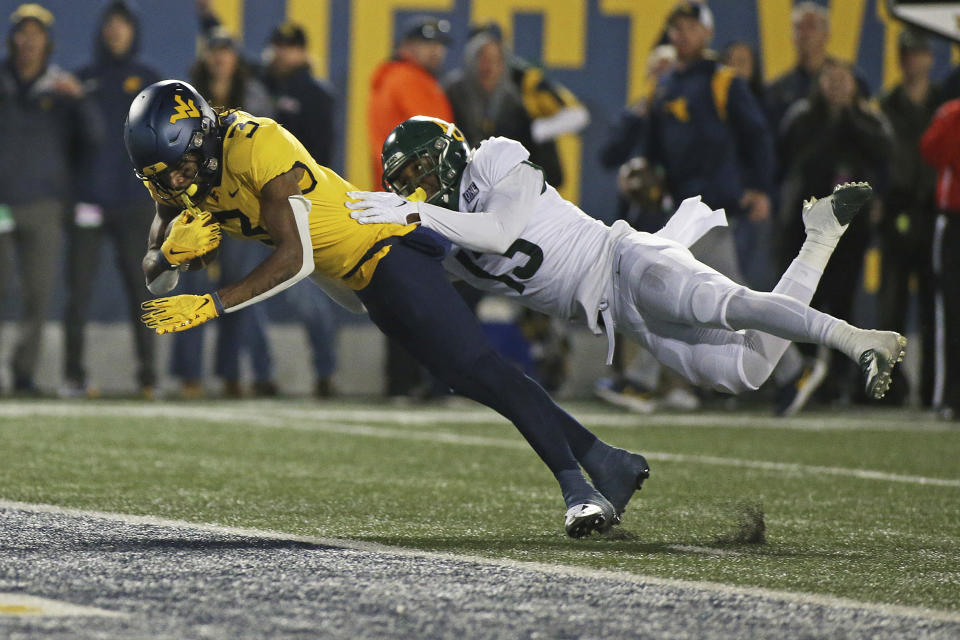 West Virginia wide receiver Kaden Prather scores a touchdown as Baylor safety Al Walcott (13) defends during the second half of an NCAA college football game in Morgantown, W.Va., Thursday, Oct. 13, 2022. (AP Photo/Kathleen Batten)