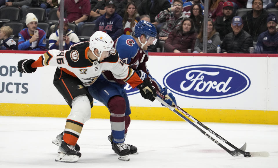 Anaheim Ducks defenseman Ilya Lyubushkin, left, ties up Colorado Avalanche defenseman Devon Toews during the third period of an NHL hockey game Tuesday, Dec. 5, 2023, in Denver. (AP Photo/David Zalubowski)