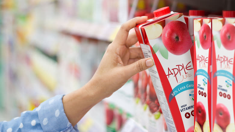 hand grabbing apple juice carton