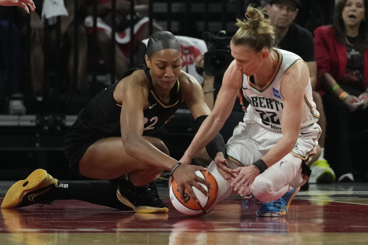 Las Vegas Aces forward A'ja Wilson, left, and New York Liberty guard Courtney Vandersloot scramble for the ball during the first half in Game 1 the 2023 WNBA Finals on Oct. 8, 2023, in Las Vegas. (AP Photo/John Locher)
