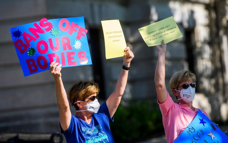 Tracy Rater, left, and Terresa Rater, right, hold signs during the Bans Off Our Bodies rally at the Monroe County Courthouse on Saturday, May 14, 2022.