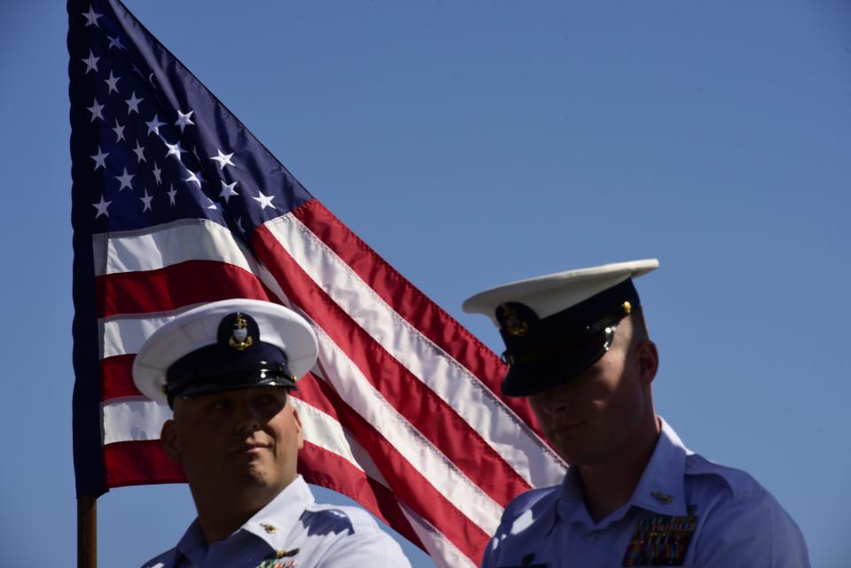 Senior Chief John Boyer (left) and Senior Chief Kyle Thomas listen to remarks by commander of Coast Guard Sector Detroit Capt. Brad Kelly during the change of command ceremony on Friday, June 17, 2022, at the U.S. Coast Guard Station in Port Huron.
