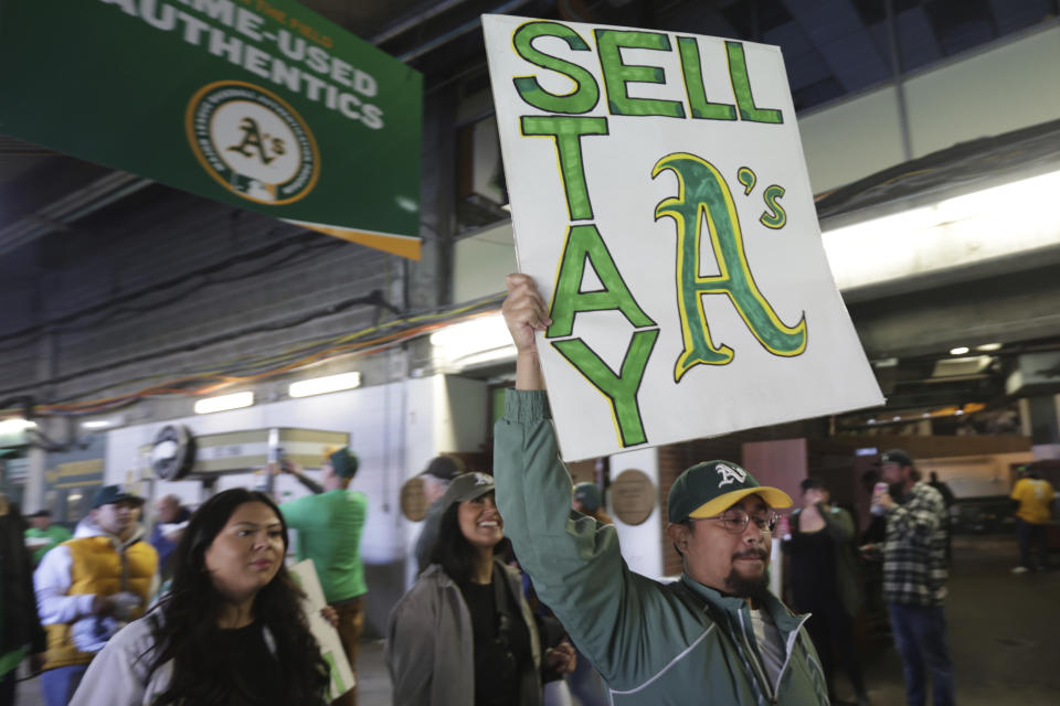 A fan holds a sign to protest the Oakland Athletics' planned move to Las Vegas, before a baseball game between the Athletics and the Tampa Bay Rays in Oakland, Calif., Tuesday, June 13, 2023. (AP Photo/Jed Jacobsohn)