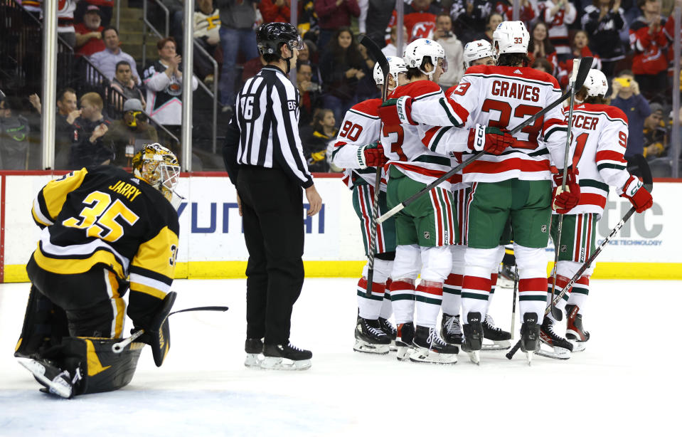 The New Jersey Devils celebrate after Dawson Mercer scored a goal against Pittsburgh Penguins goaltender Tristan Jarry (35) during the second period of an NHL hockey game Tuesday, April 4, 2023, in Newark, N.J. (AP Photo/Noah K. Murray)