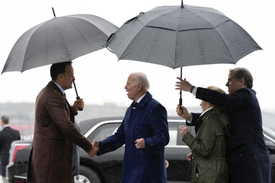 President Joe Biden shakes hands with Ireland's Taoiseach Leo Varadkar, left,as his son Hunter Biden, right, and his sister Valerie Biden Owens, second from right, hold an umbrella for him at Dublin International Airport in Dublin, Ireland, Wednesday, April 12, 2023. (AP Photo/Patrick Semansky)