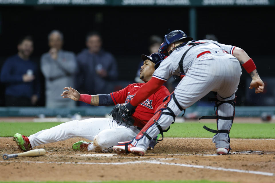 Cleveland Guardians' Jose Ramirez, left, is tagged out at home plate by Minnesota Twins catcher Christian Vazquez, right, while attempting to score on a single by Oscar Gonzalez during the seventh inning of a baseball game, Friday, May 5, 2023, in Cleveland. (AP Photo/Ron Schwane)
