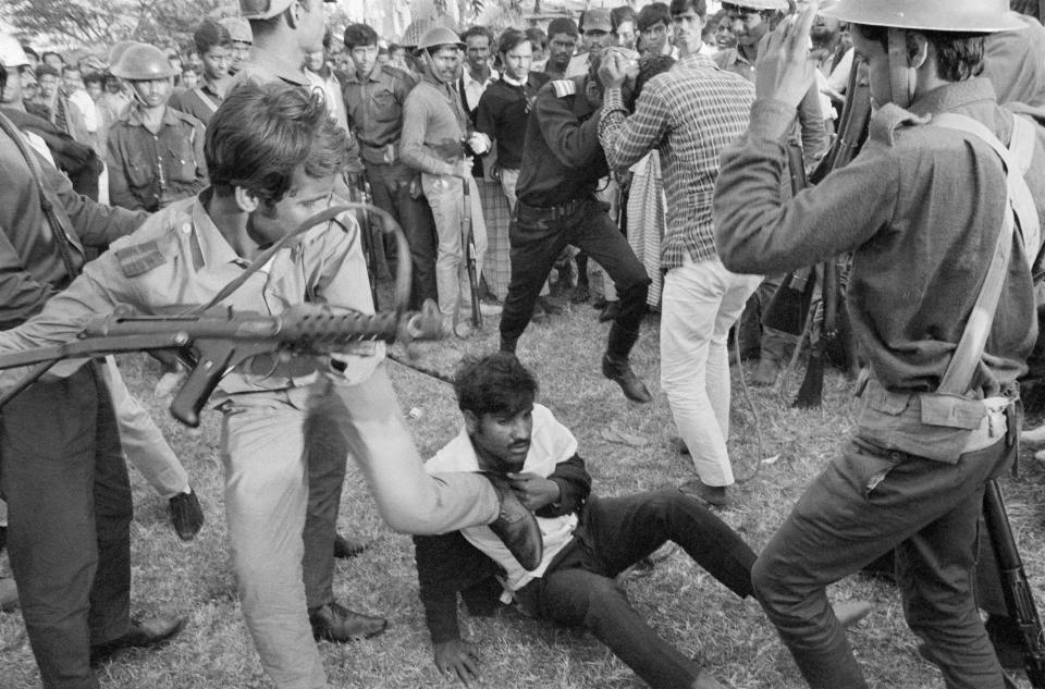 FILE - In this Dec. 18, 1971, file photo, Bangladeshi guerrillas beat a victim as they torture and execute four men suspected of collaborating with Pakistani militiamen accused of murder, rape and looting during months of civil war in Dacca, Bangladesh. Bangladesh is celebrating 50 years of independence this year. (AP Photo/Horst Faas, Michel Laurent, File)