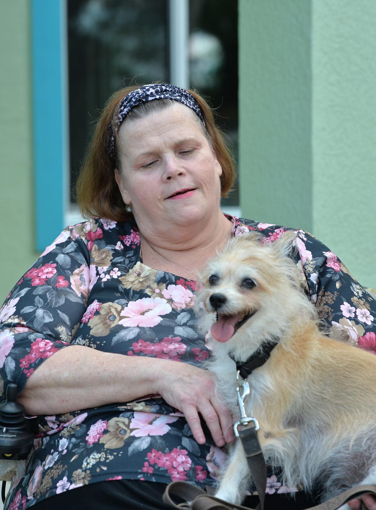 Homeowner Marie Salmons – with her dog, Evan – in front of her newly rebuilt home.