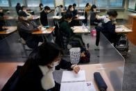 A student checks the time as the others wait for the start of the annual college entrance examinations amid the coronavirus disease (COVID-19) pandemic at an exam hall in Seoul
