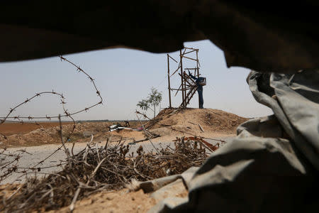 A Palestinian man inspects an Islamic Jihad observation post after it was targeted in Israeli tank shelling, in the southern Gaza Strip May 27, 2018. REUTERS/Ibraheem Abu Mustafa