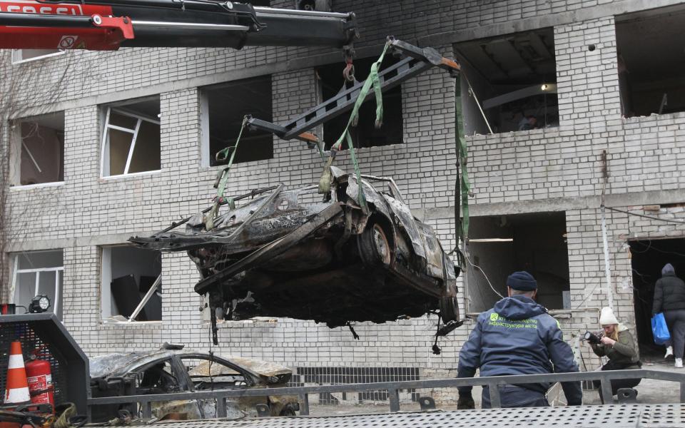 A burned out car is winched away from the site of a Russian strike in Dnipropetrovsk