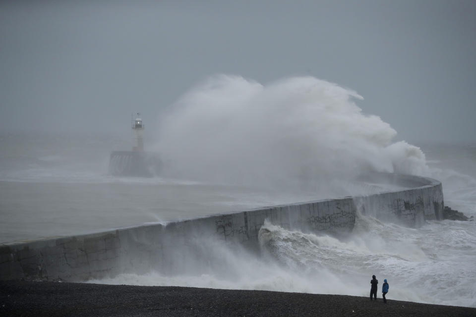 Waves crash over the harbour wall by a lighthouse as Storm Ciara hits Newhaven, on the south coast of England, Sunday, Feb. 9, 2020. Trains, flights and ferries have been cancelled and weather warnings issued across the United Kingdom and in northern Europe as the storm with winds expected to reach hurricane levels batters the region. (AP Photo/Matt Dunham)