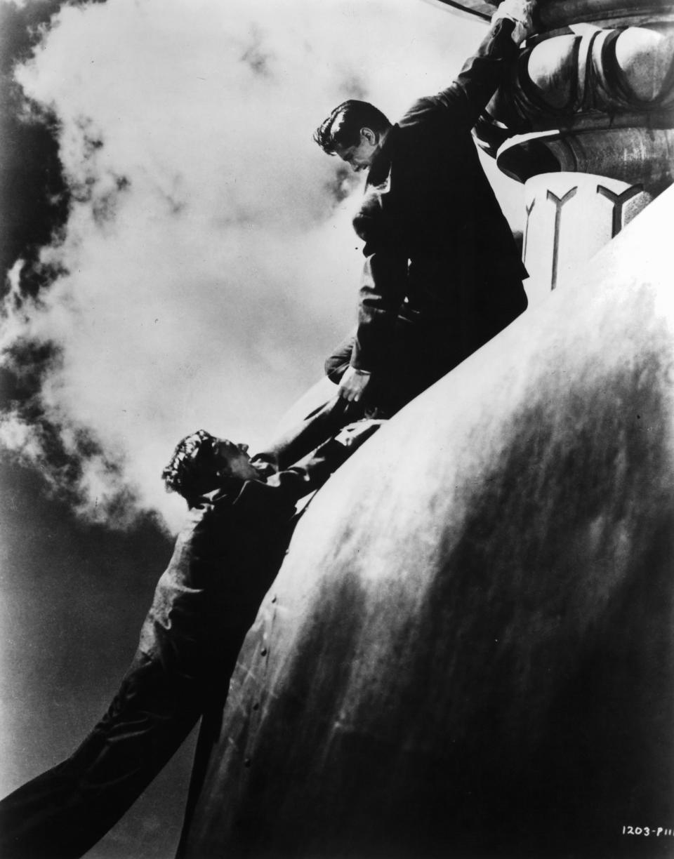 Norman Lloyd and Robert Cummings fighting on top of the Statue of Liberty in a scene from the 1942 spy thriller, 