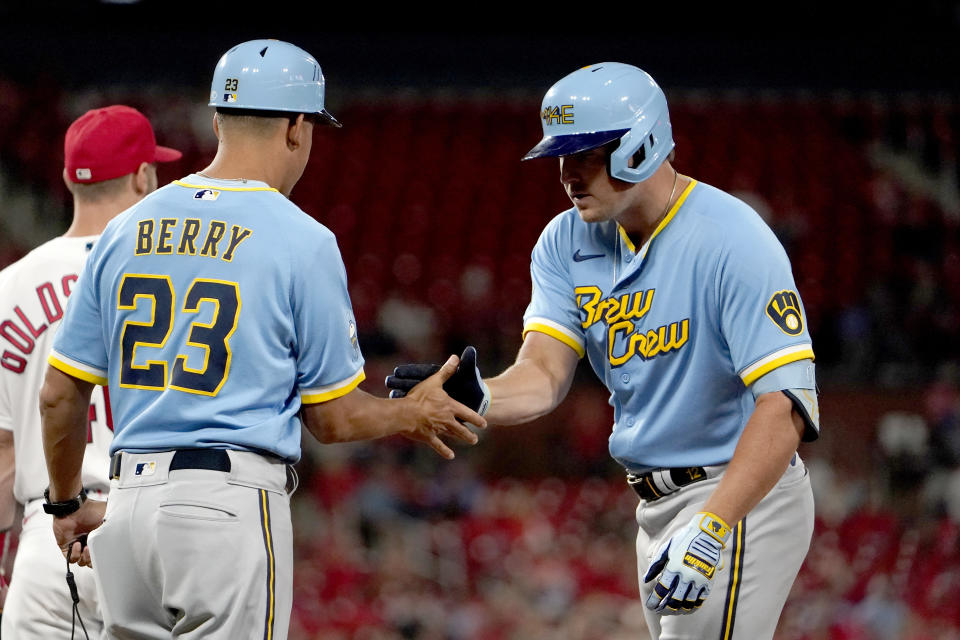 Milwaukee Brewers' Hunter Renfroe is congratulated by first base coach Quintin Berry (23) after hitting an RBI single during the eighth inning of a baseball game against the St. Louis Cardinals Tuesday, Sept. 13, 2022, in St. Louis. (AP Photo/Jeff Roberson)