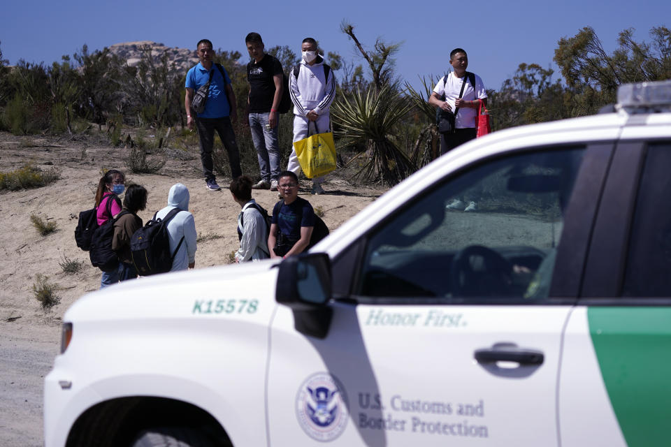 FILE - Asylum-seekers wait in a makeshift camp after crossing the nearby border with Mexico, Sept. 20, 2023, near Jacumba Hot Springs, Calif. Most people in the U.S. see Mexico as an essential partner to stop drug trafficking and illegal border crossings, even as they express mixed views of Mexico's government, according to a new poll. (AP Photo/Gregory Bull, File)