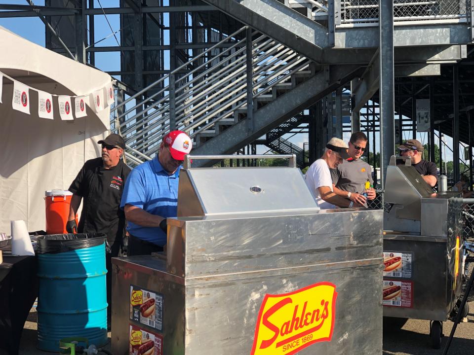 Watkins Glen International President Michael Printup, left, and Sahlen Packing Company owner/president Joe Sahlen serve hot dogs to fans during the Sahlen's Six Hours of The Glen weekend June 28, 2019 at WGI.
