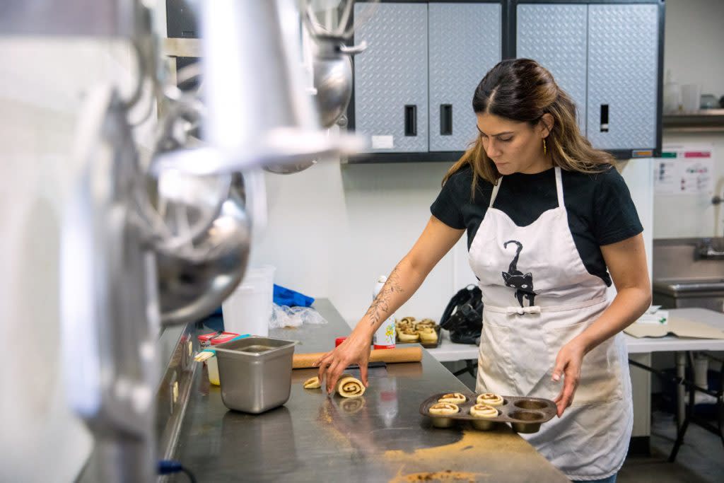 A woman makes cinnamon rolls in a rented commercial kitchen. 