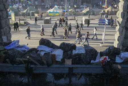 People walk past pro-European integration supporters' tents near Independence Square where the supporters are holding a rally, in Kiev, December 26, 2013. REUTERS/Gleb Garanich