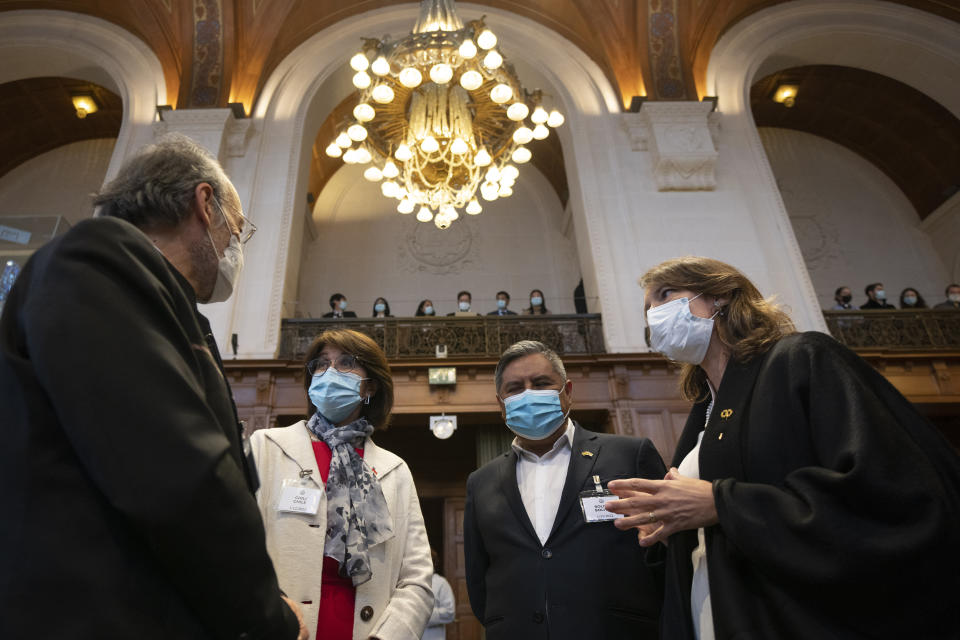 Ximean Fuentes, Chile's vice-minister for foreign affairs, second left, Chilean lawyer Carolina Valdivia Torres, right, and Bolivian Foreign Minister, Rogelio Mayta, second right talk prior to the reading of the verdict at the World Court in The Hague, Netherlands, Thursday, Dec. 1, 2022, where the UN's top court rules on a dispute about a river that crosses Chile's and Bolivia's border, in a case seen as important jurisprudence at a time when fresh water is becoming an increasingly coveted world resource. (AP Photo/Peter Dejong)