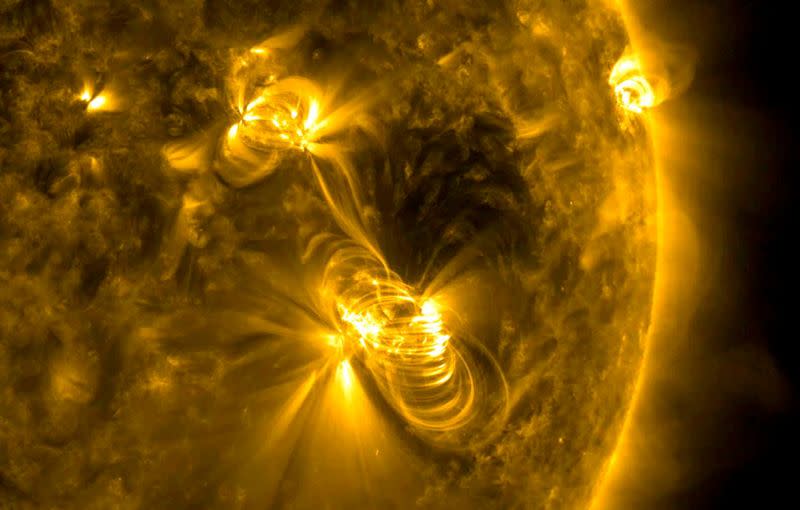 FILE PHOTO: NASA image of a medium-sized (M2) solar flare and a coronal mass ejection (CME) erupting from the same, large active region of the sun